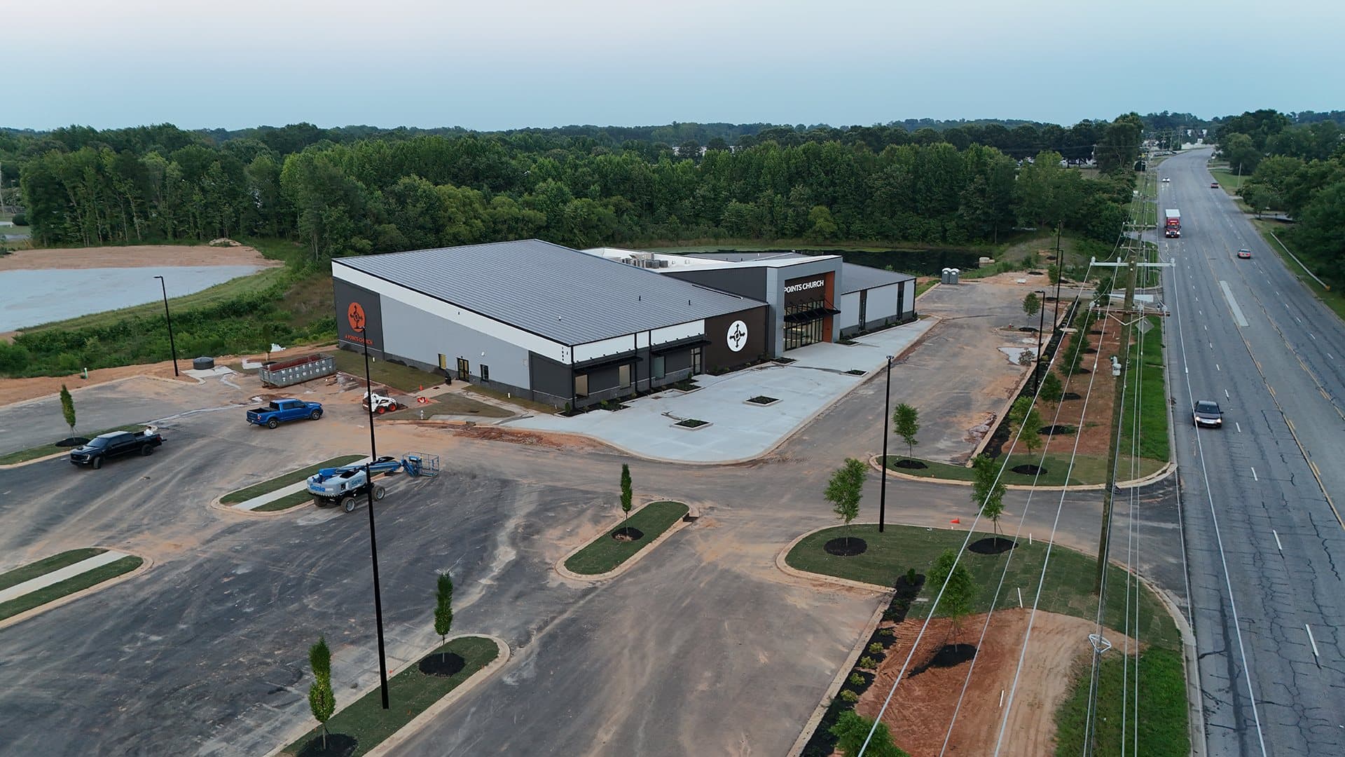 Aerial view of the new 4 Points Church building, parking lot and stormwater pond beside a highway