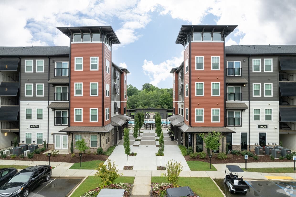 Twin four-story apartment buildings framing a landscaped courtyard