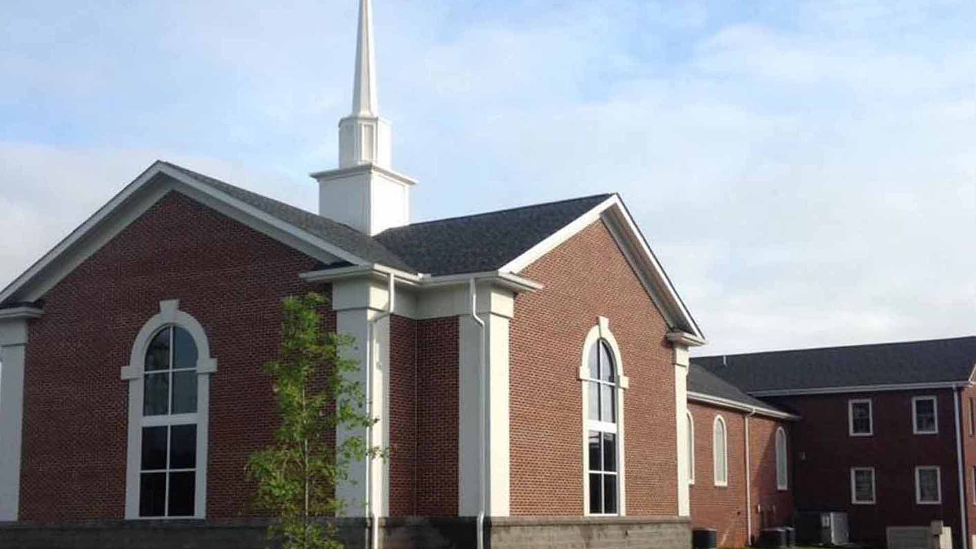 Brick sanctuary of New Hope Baptist Church with a white steeple
