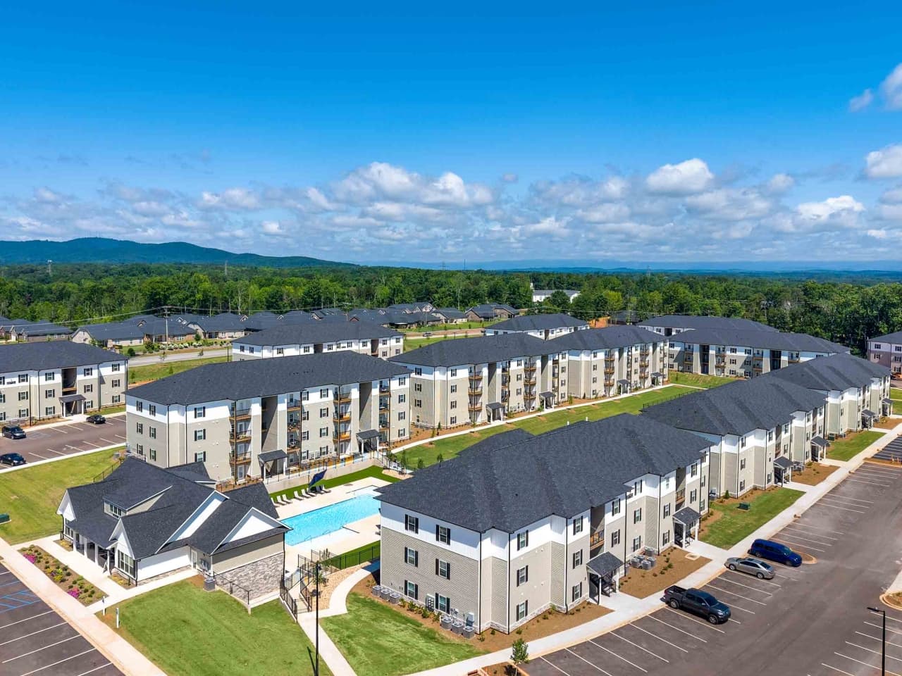 Aerial view of Northbrook apartment buildings and pool with mountains beyond